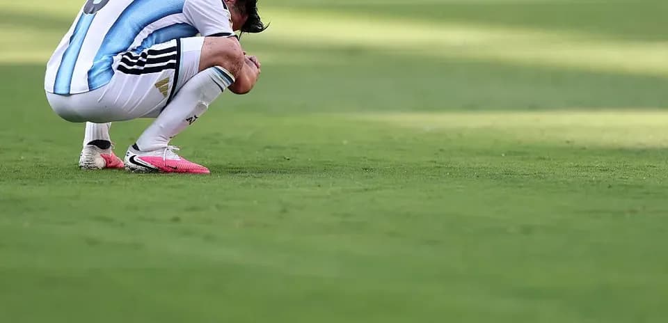 Futbolchi g'ayrat bilan o'tirgan holatda