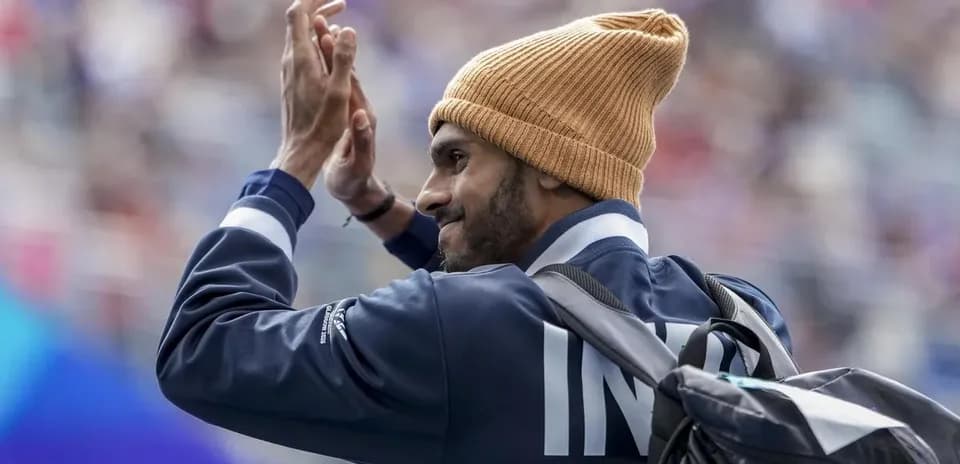 Athlete waving while wearing a beanie and jacket