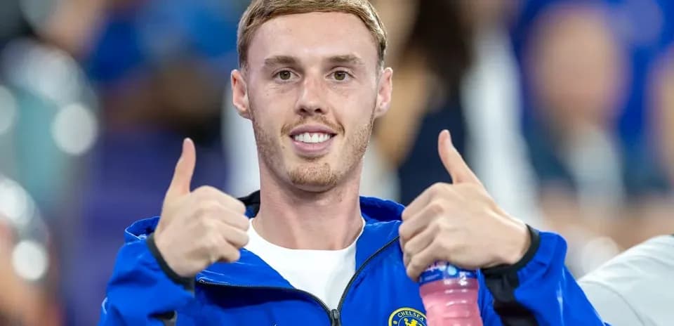 Futbolchi Chelsea formasi bilan qo'l ko'tarib turibdi