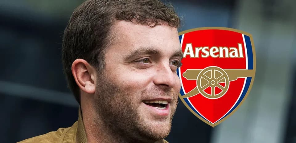 Shaxs Arsenal logosi oldida kulayotgan