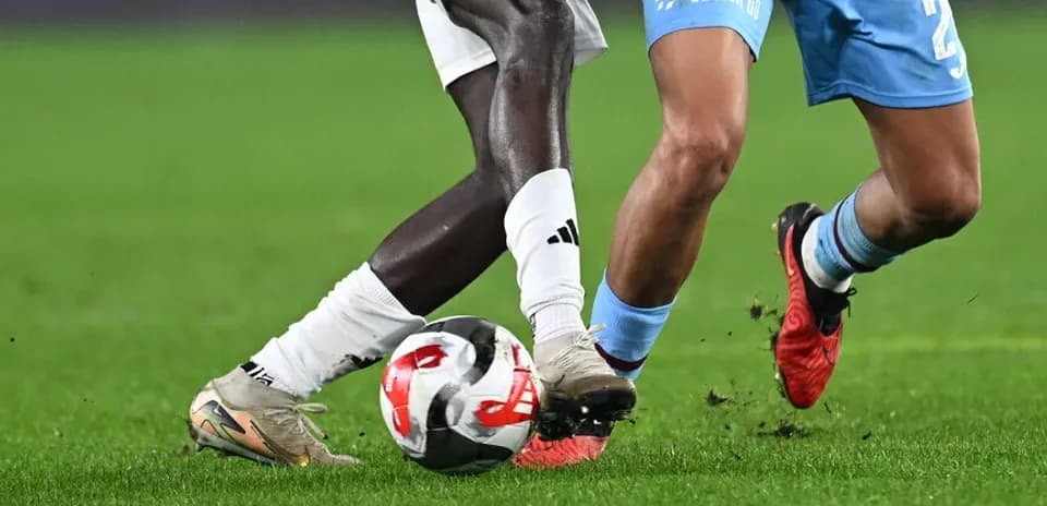 Two players challenging for the ball on field