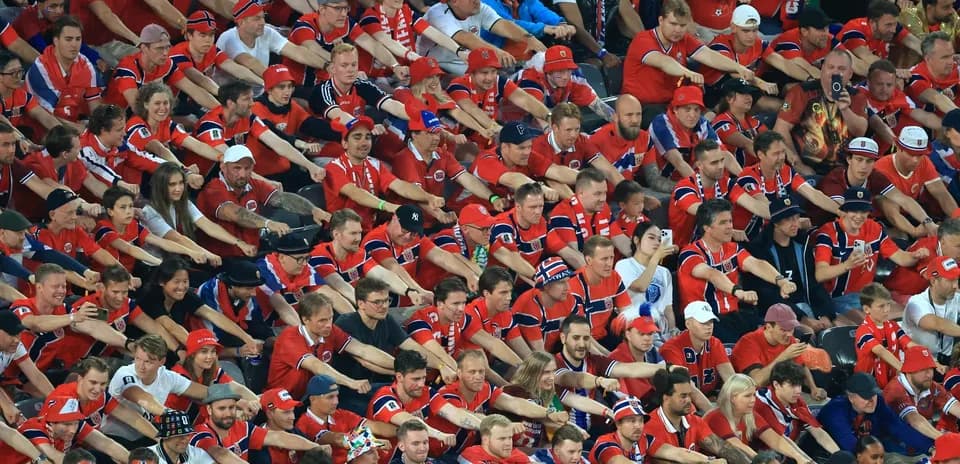 Fans in red jerseys celebrating at stadium