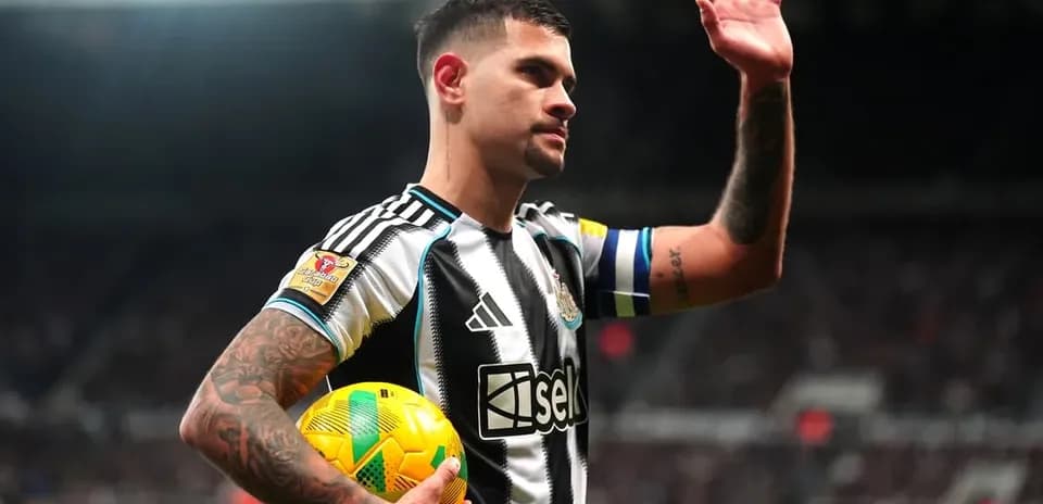 Futbolchi to'p bilan stadionda qo'lini ko'taradi