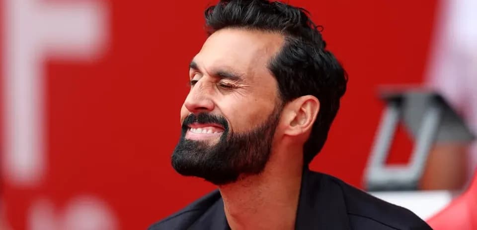 Man smiling while sitting on bench with red background