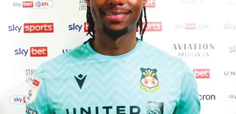 Goalkeeper posing in club kit with sponsor logos