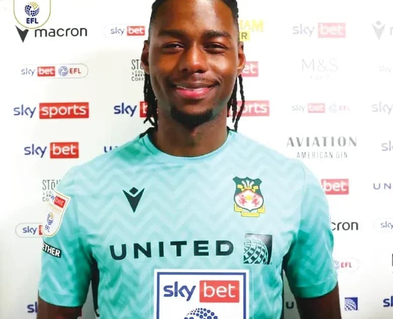 Goalkeeper posing in club kit with sponsor logos