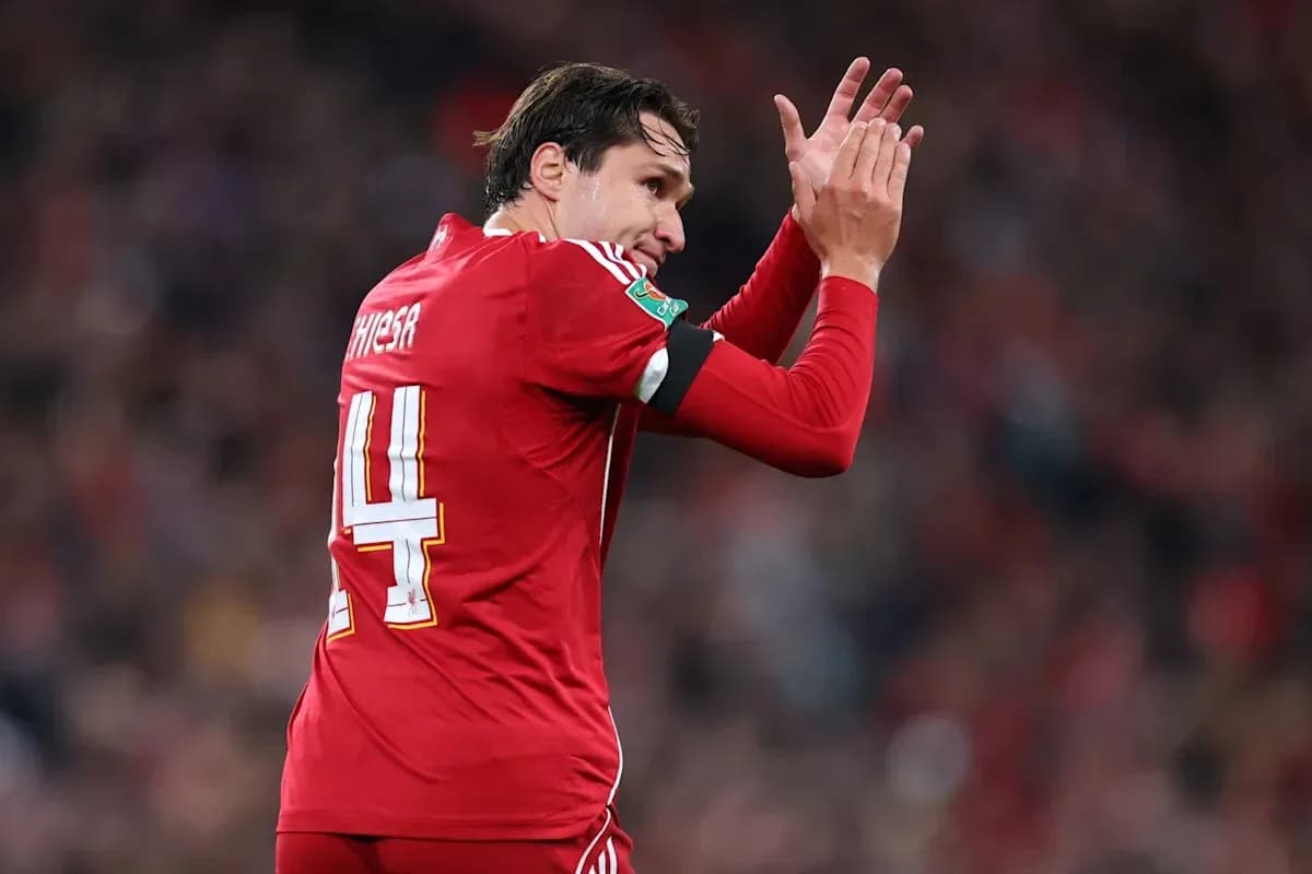 Futbolchi maydonda qo'llarini ko'tarib olqishlayapti