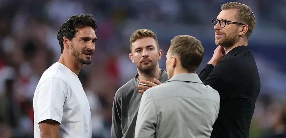 Four men conversing on the pitch before match