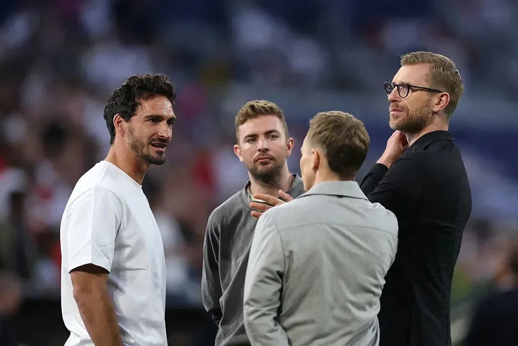 Four men conversing on the pitch before match