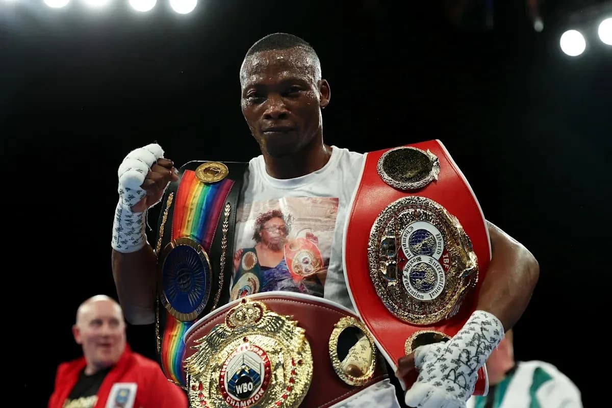 Boxer holding multiple championship belts after victory
