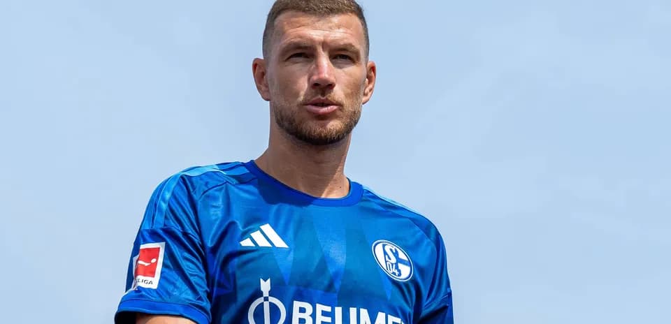Futbolchi ko'k forma kiygan, oldinga qarab turibdi