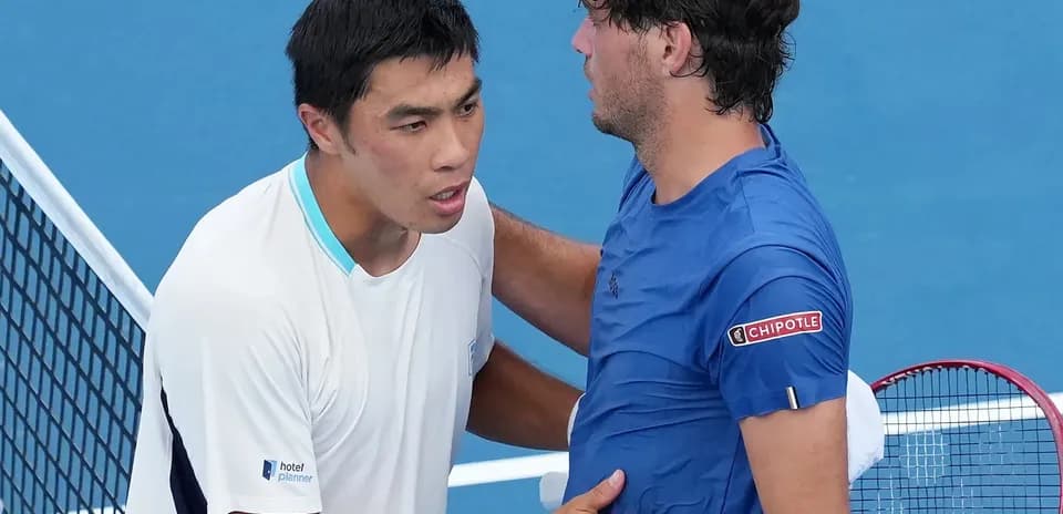 Two tennis players shaking hands at net