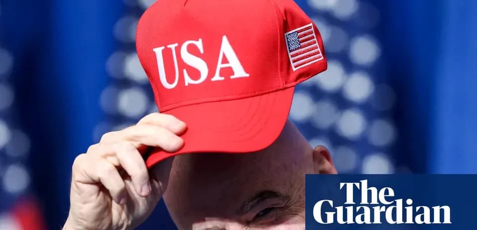 Bald man holding red USA cap at event