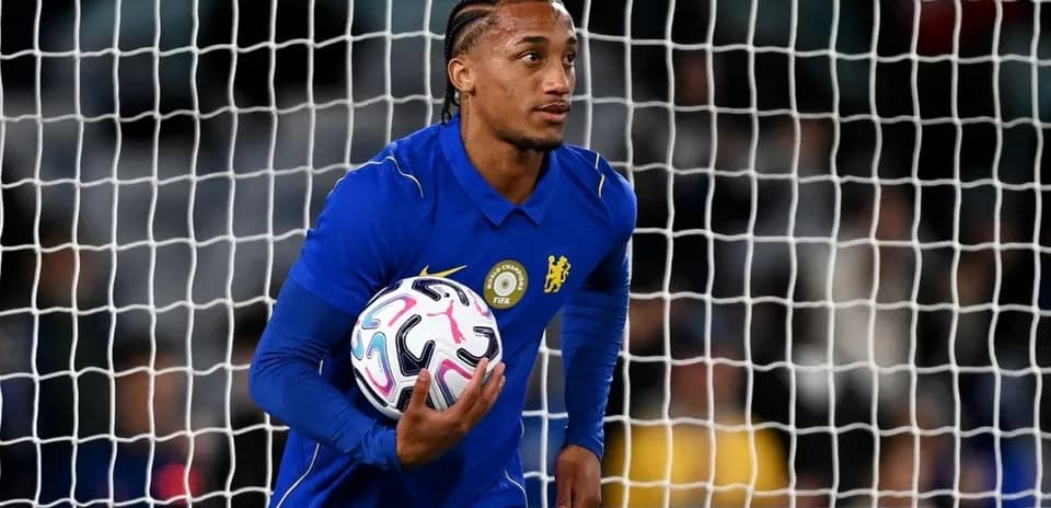 Goalkeeper holding ball in front of goal net