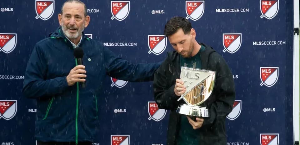 Lionel Messi holding MLS trophy at press event