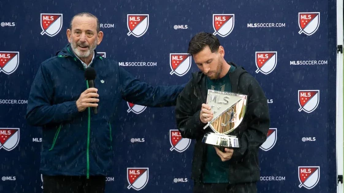 Lionel Messi holding MLS trophy at press event