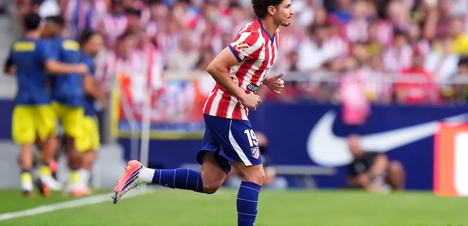 Futbolchi Atletico Madrid formasida maydonda yugurmoqda