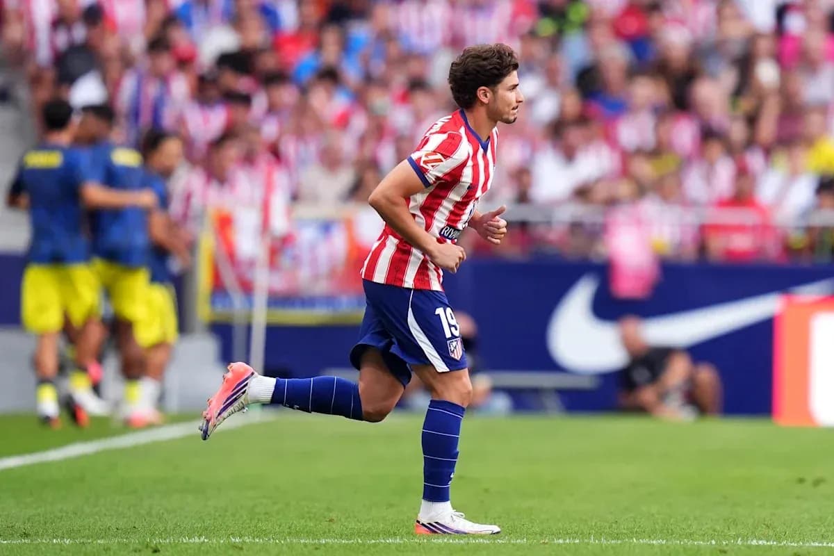 Futbolchi Atletico Madrid formasida maydonda yugurmoqda