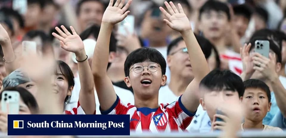 Fan wearing Atlético Madrid jersey celebrating in crowd