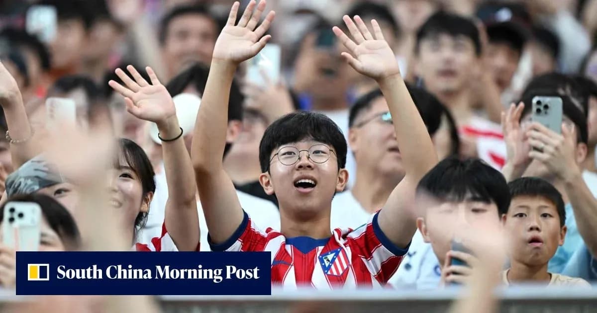 Fan wearing Atlético Madrid jersey celebrating in crowd