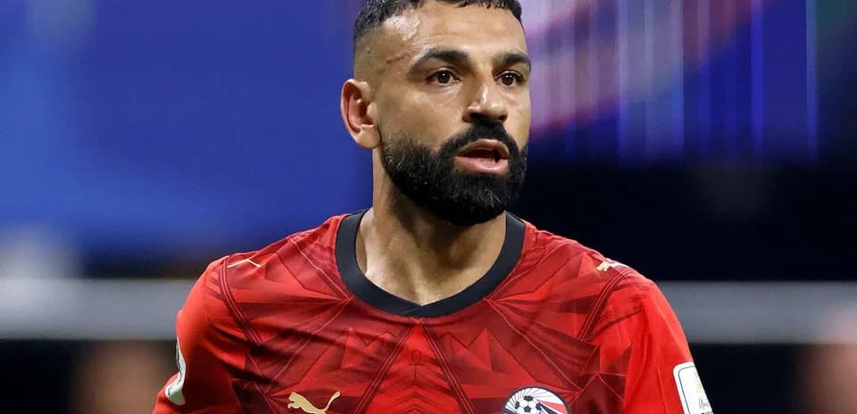 Futbolchi maydonda harakatda, qizil forma kiygan