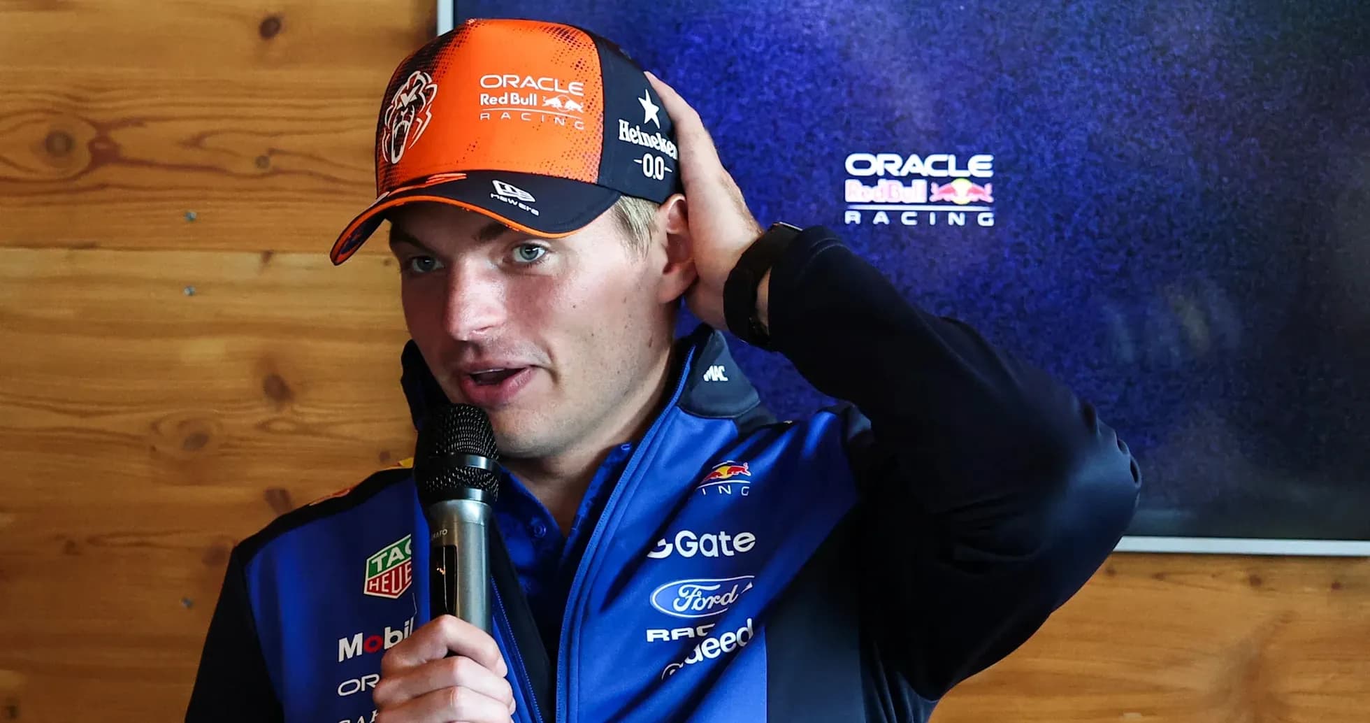 Max Verstappen speaking at press conference with microphone