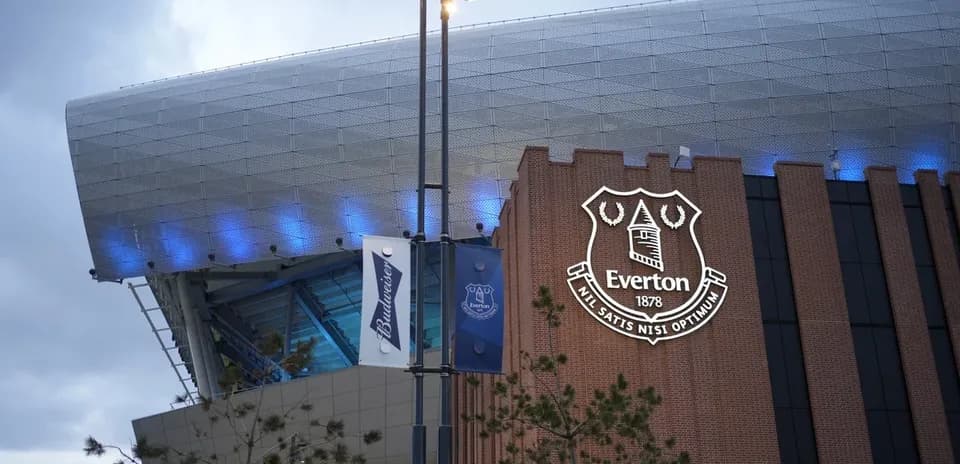 Everton stadium exterior with club logo illuminated