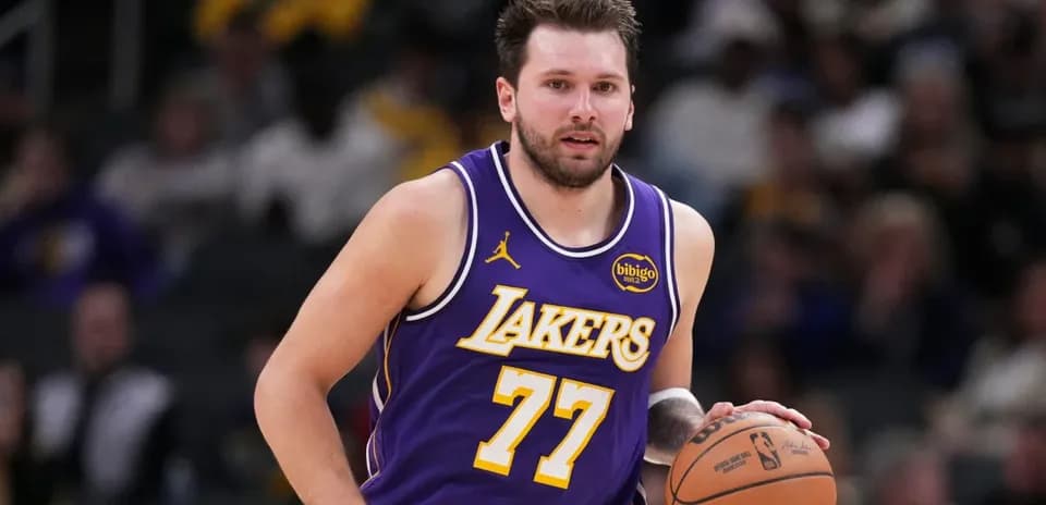 O'yinchi Lakers formasida to'p bilan harakatlanmoqda