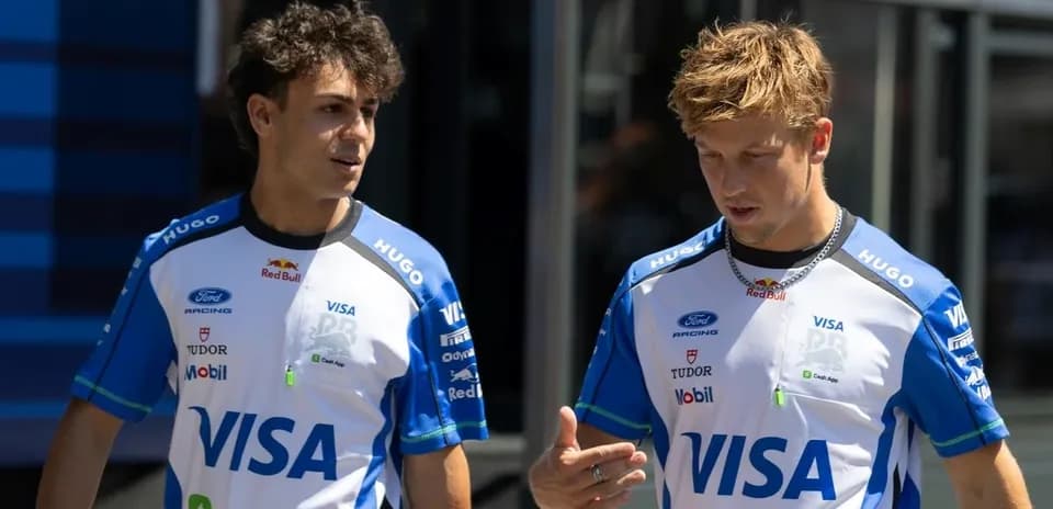 Two racing team members discussing in paddock