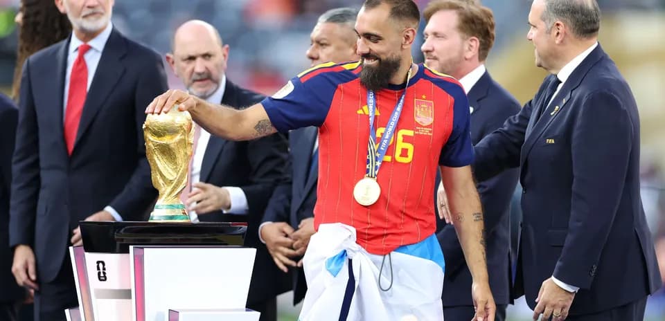Futbolchi kubokni ushlab turgan shaxs