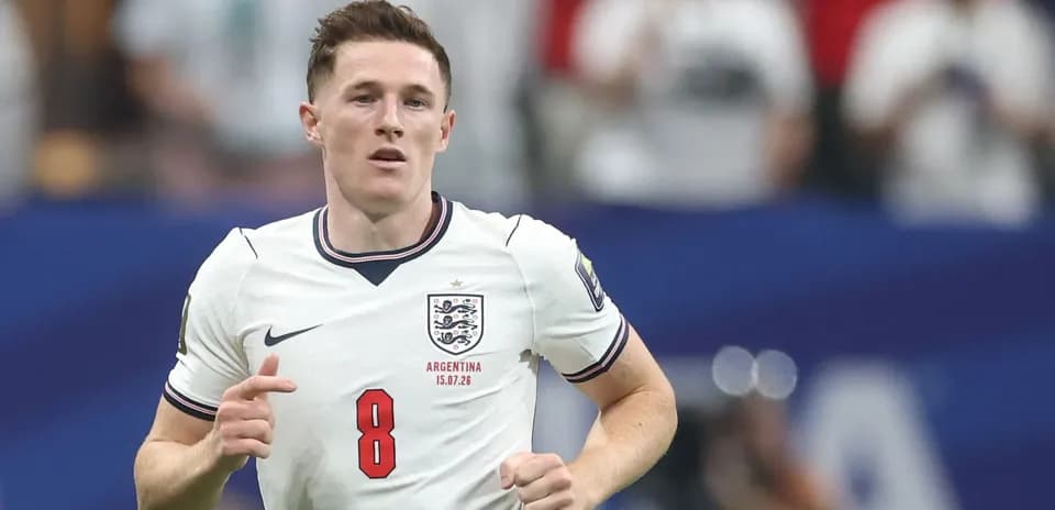 Futbolchi maydonda yugurayotgan England formasida