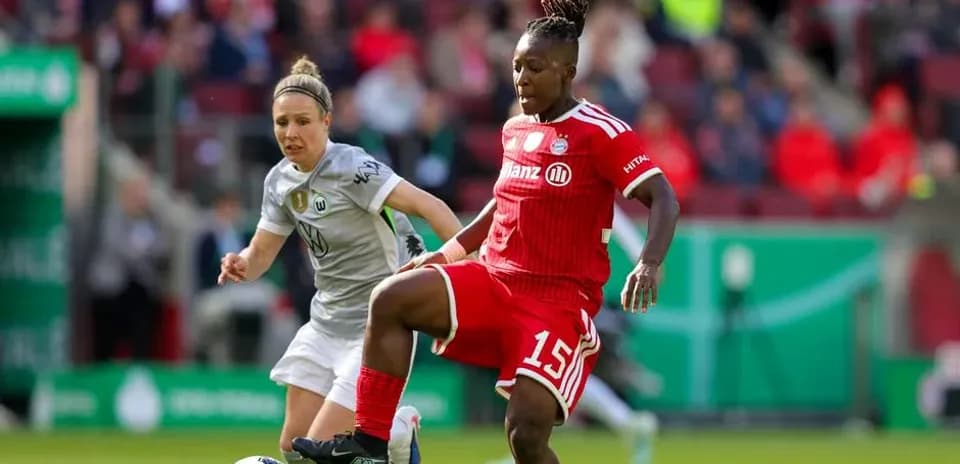 Bayern player dribbling past Wolfsburg defender during match