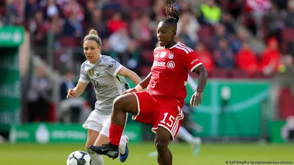 Bayern player dribbling past Wolfsburg defender during match