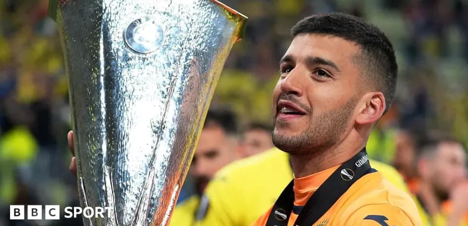 Futbolchi yutgan kubokni ko'tarib turibdi
