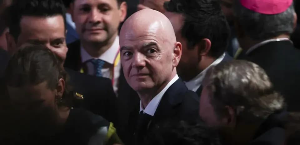 Man in suit surrounded by a crowd of people