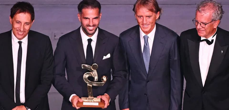 Four men posing with a trophy at an event