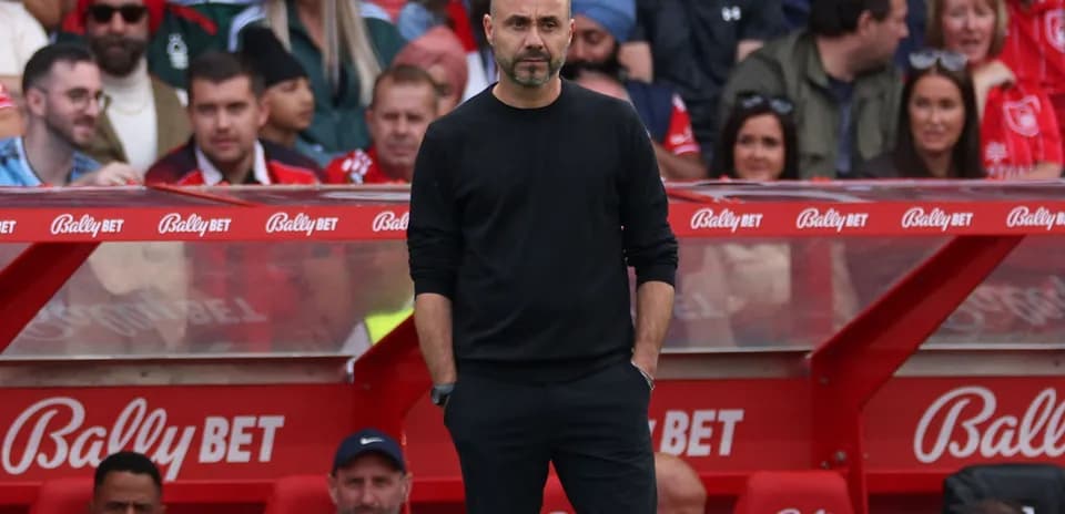 Coach observing match from sideline bench