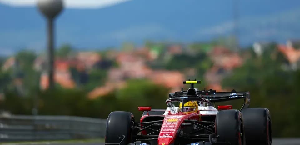 Ferrari F1 car racing on track with mountains background