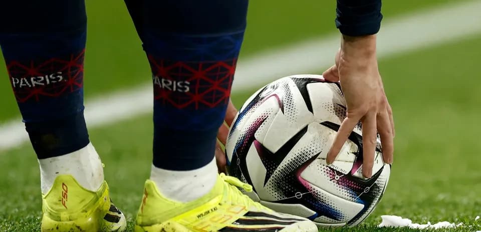 Futbol to'pini joyiga qo'yayotgan o'yinchi