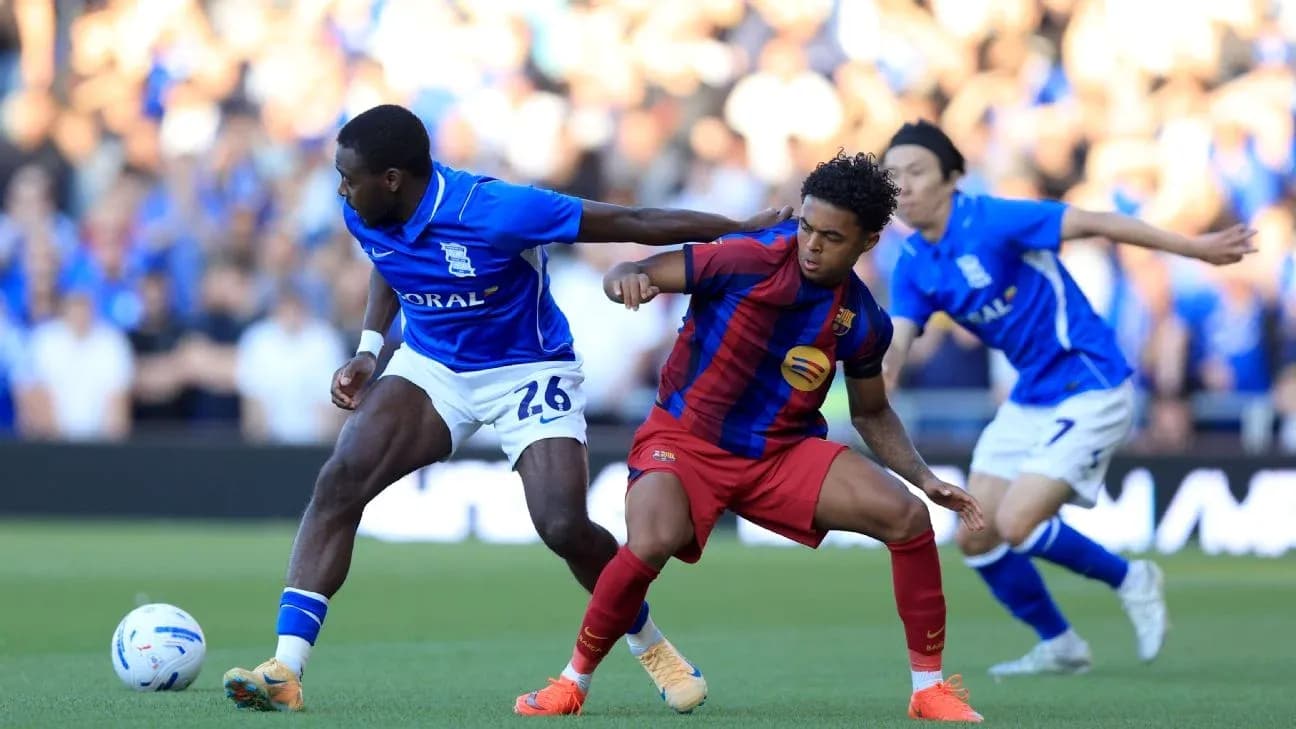 Birmingham player tackling Barcelona player during match
