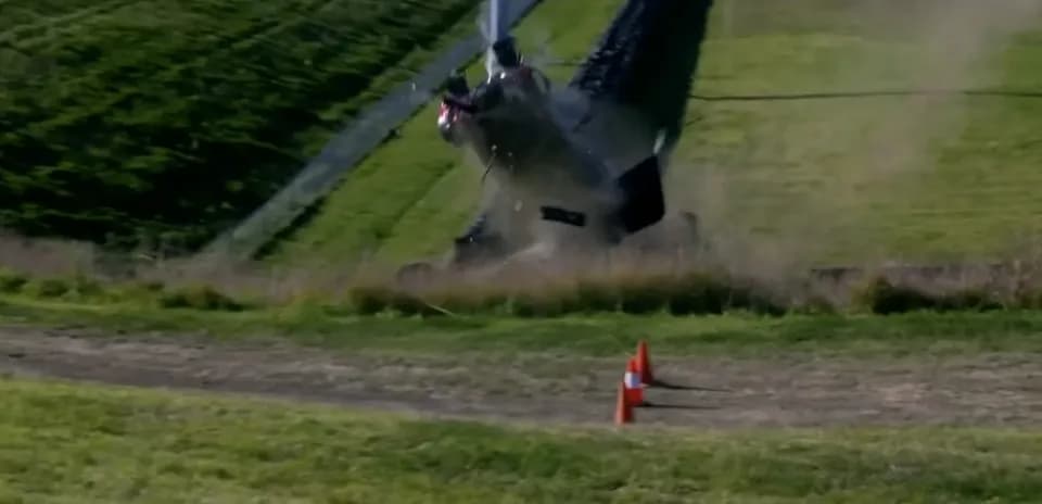 Helicopter crashing on grassy terrain with cones