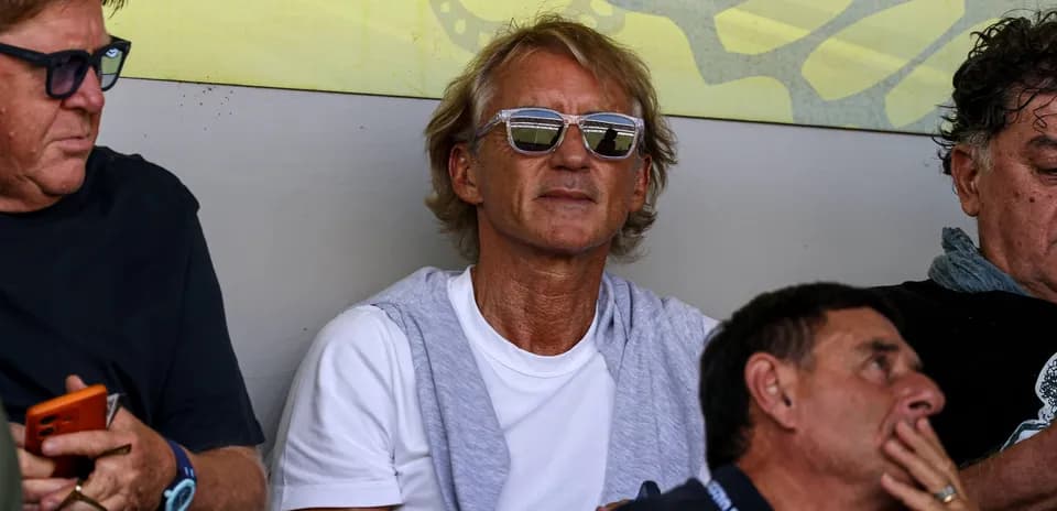 Man in sunglasses sitting with friends in stands