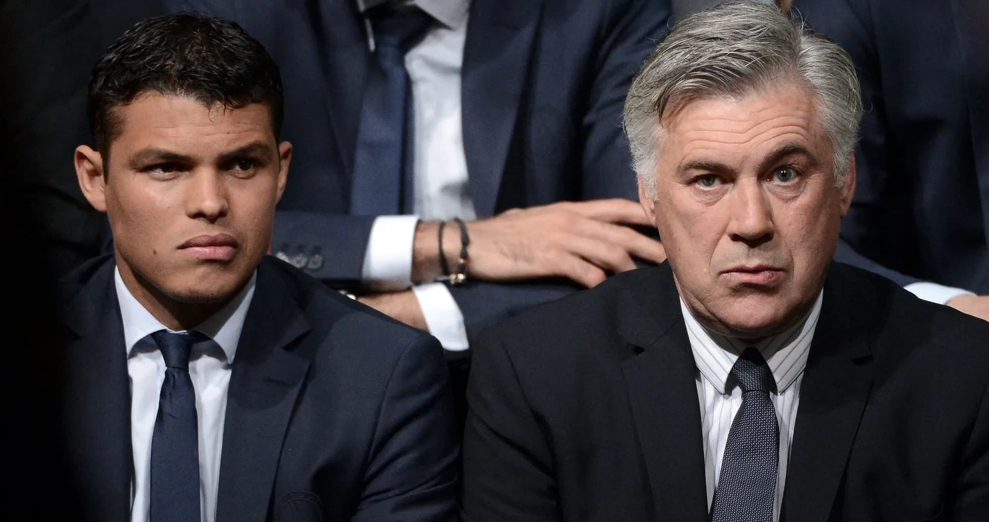 Two men in suits sitting at an event