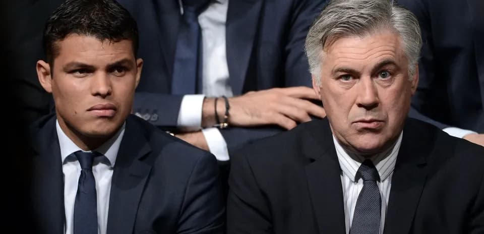 Two men in suits sitting at an event