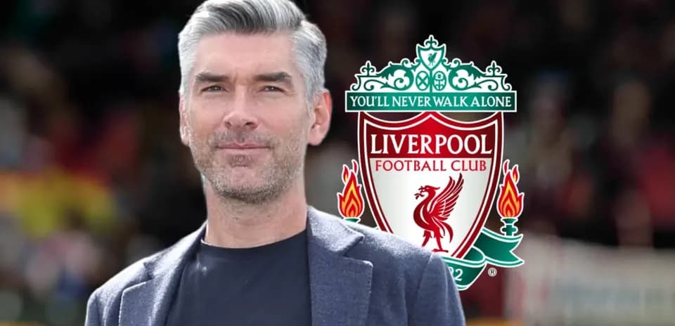 Man standing in front of Liverpool FC logo