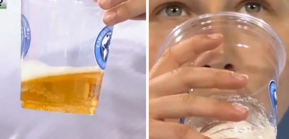 Person holding cup of beer, preparing to drink