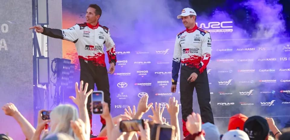 Rally drivers celebrating on stage with fans