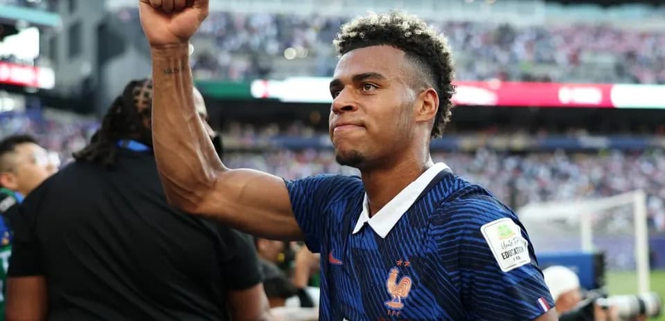 Futbolchi g'alaba bilan qo'lini ko'tarib turibdi