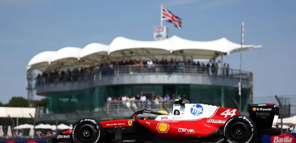 Formula 1 car racing past grandstand at event