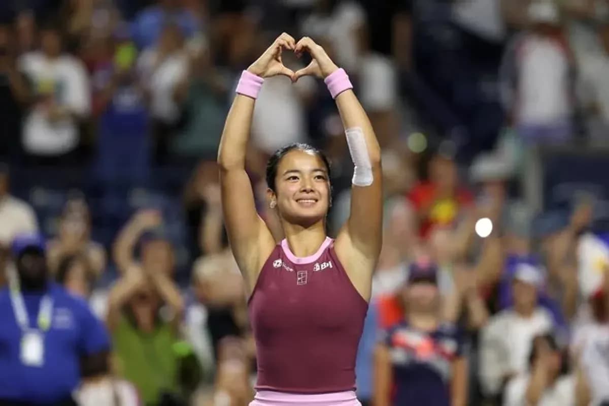 Tennis player celebrating with heart gesture after match